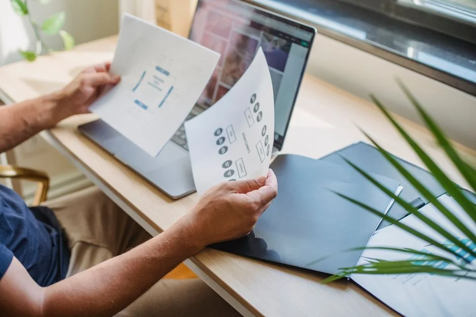 Close-up view of hands using a shopping website displayed on a laptop screen indoors.